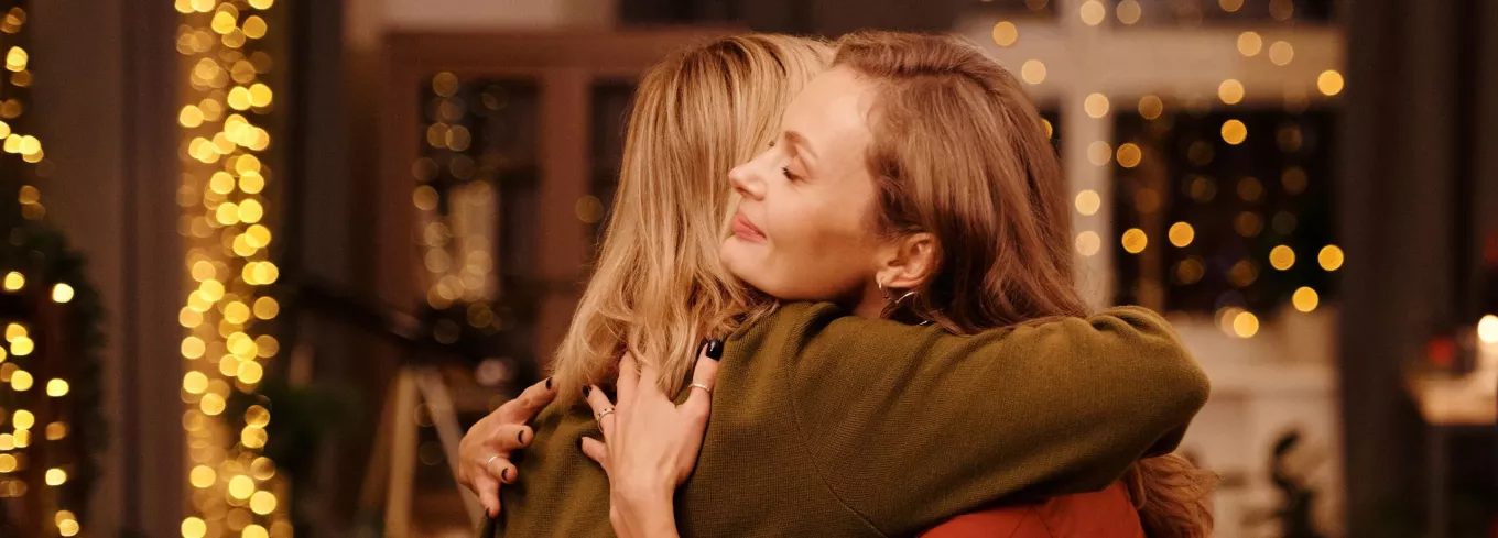 Zwei Frauen umarmen sich, weil sie sich schöne Überraschungen zu Weihnachten bereitet haben | Pluxee 