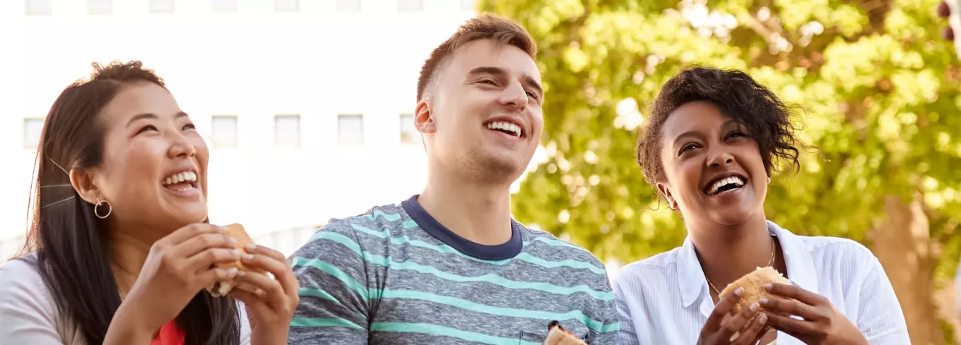 Team lacht mit Essen in der Hand | Pluxee 