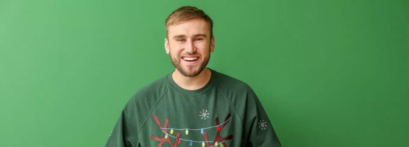 Mann freut sich über Benefits, welche er zu Weihnachten vom Arbeitgeber erhalten hat | Pluxee 