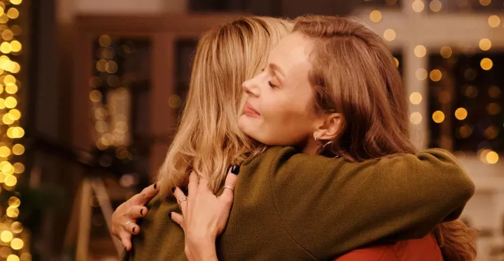 Zwei Frauen umarmen sich, weil sie sich schöne Überraschungen zu Weihnachten bereitet haben | Pluxee