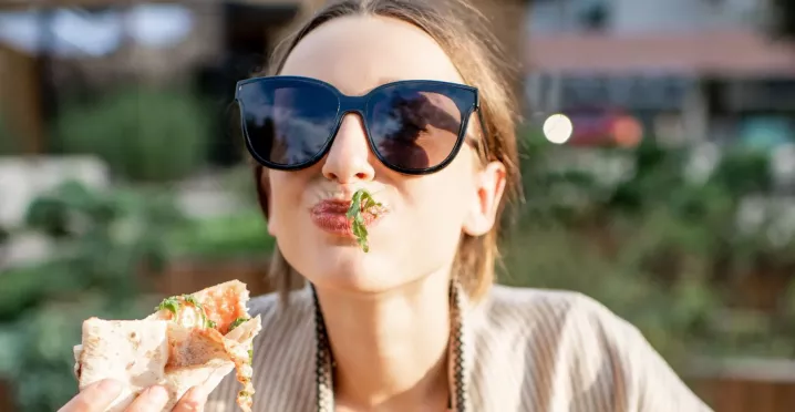 Frau genießt Essen geliefert von Lieferando & bezahlt mit Pluxee Gutscheinen