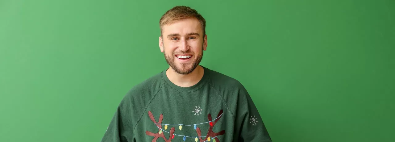 Mann freut sich über Benefits, welche er zu Weihnachten vom Arbeitgeber erhalten hat | Pluxee