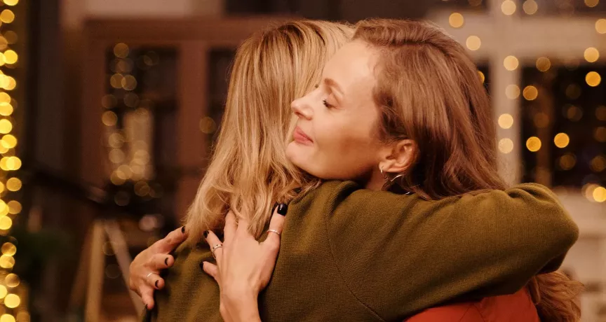 Zwei Frauen umarmen sich, weil sie sich schöne Überraschungen zu Weihnachten bereitet haben | Pluxee