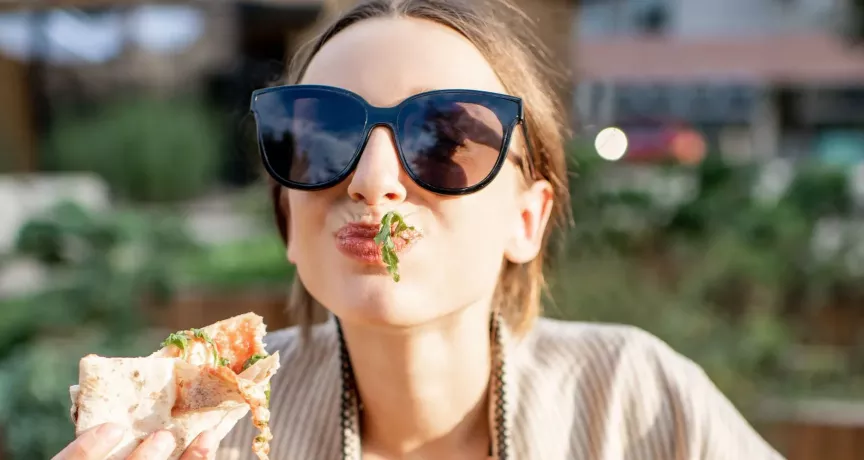 Frau genießt Essen geliefert von Lieferando & bezahlt mit Pluxee Gutscheinen