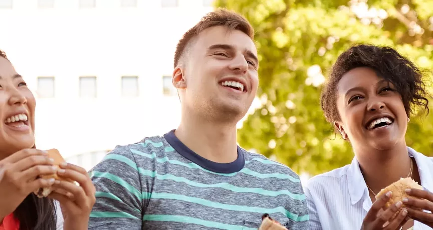 Team lacht mit Essen in der Hand | Pluxee