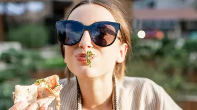 Frau genießt Essen geliefert von Lieferando & bezahlt mit Pluxee Gutscheinen