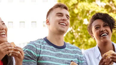 Team lacht mit Essen in der Hand | Pluxee