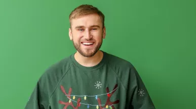Mann freut sich über Benefits, welche er zu Weihnachten vom Arbeitgeber erhalten hat | Pluxee