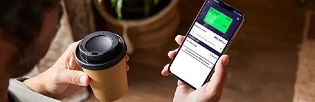 Eine Person hält ein Smartphone in der Hand, auf dem die Pluxee-App geöffnet ist. Auf dem Bildschirm ist die digitale Restaurant-Karte zu sehen.